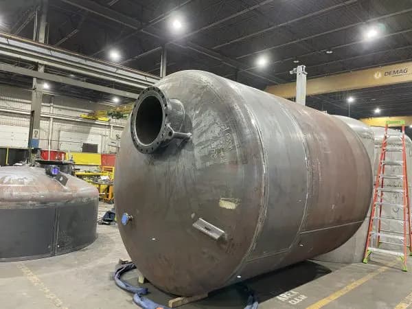 Cylindrical steel vessel shell with a flanged nozzle and dished heads